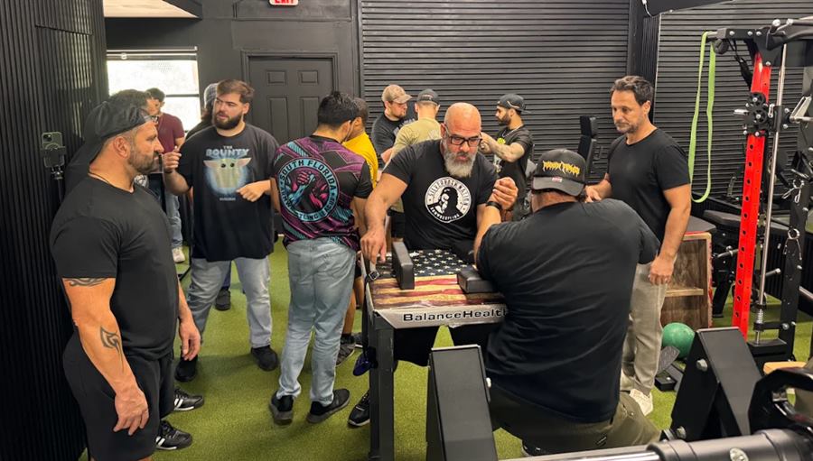 Club members gathered around an armwrestling match